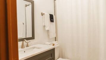 A bathroom with a sink, mirror, and toilet.