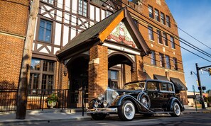 A vintage car parked in front of a building with a large sign reading "The General Store." - General Denver Hotel (Wilmington)
