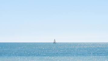 A sailboat on a calm sea with a clear sky.