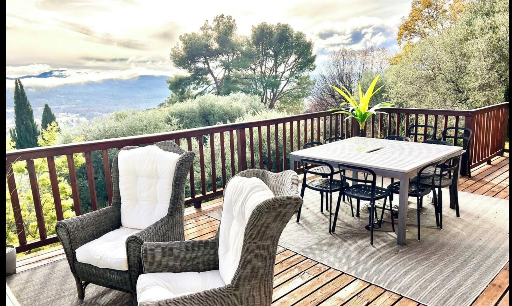 A deck with wicker furniture, a table, and chairs.