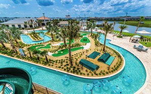 Een resort met een zwembad, inclusief een glijbaan, een putting green en ligbedden.