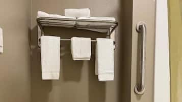 Un baño con inodoro, toallero y toallas, y barandilla.