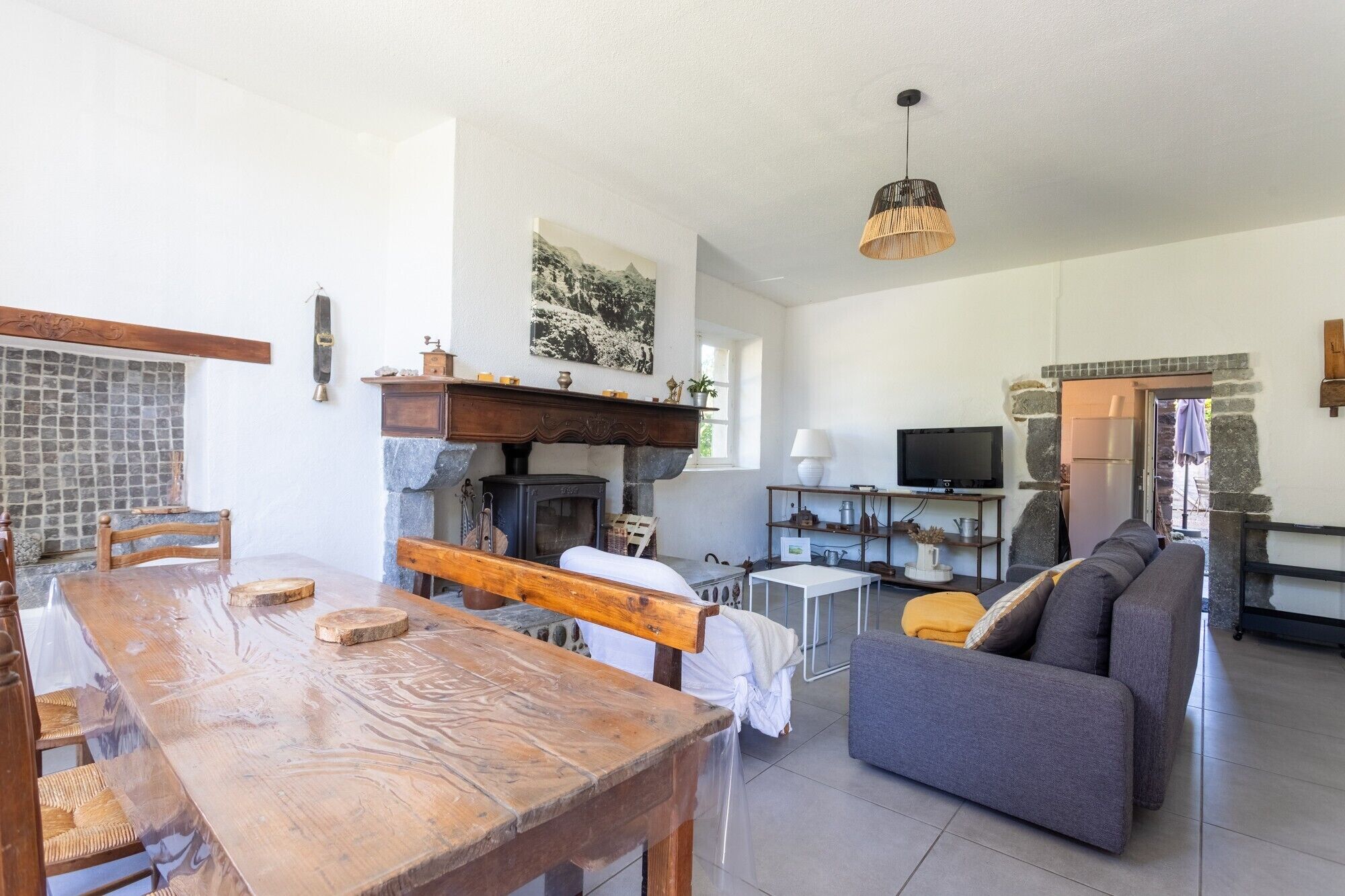 Een gezellige woonkamer met een open haard, een televisie en een bank.