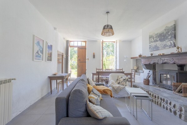 A spacious living room with a sofa, a dining table, and a fireplace.