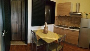 Una cocina funcional con una mesa de comedor, un refrigerador y una estufa.