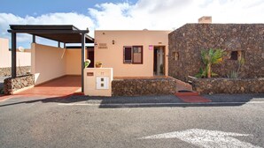 A building with a stone facade, a covered entrance, and a sign indicating 'Villa Amistad.' - Vacation Villa 'Amistad' with Private Pool, Private Terrace and Wi-Fi (Corralejo)