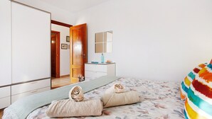 A bedroom with a bed, a mirror, a dresser, and a door leading to another room. - Vacation Villa 'Amistad' with Private Pool, Private Terrace and Wi-Fi (Corralejo)