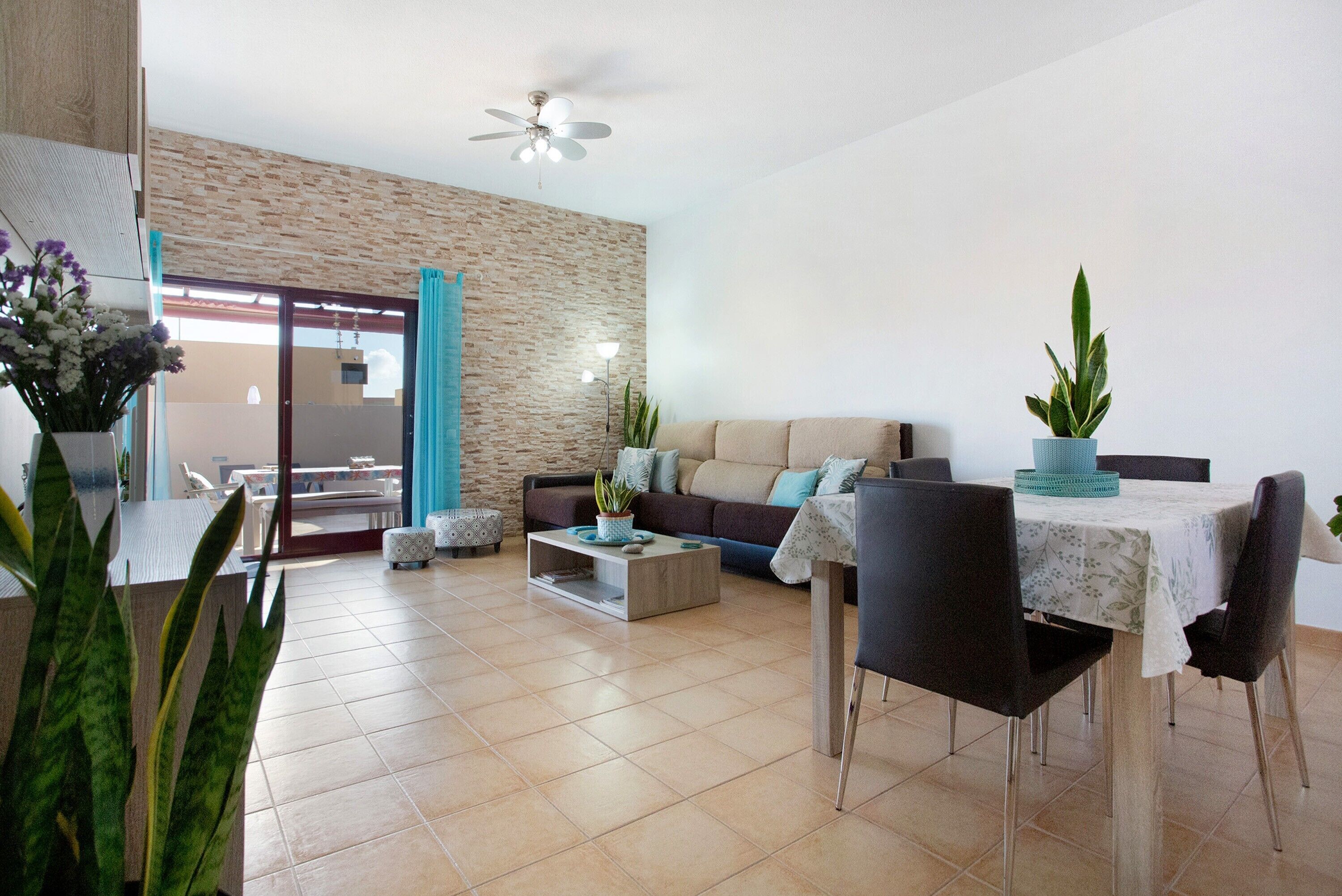 A modern living room with a sofa, coffee table, and dining table.