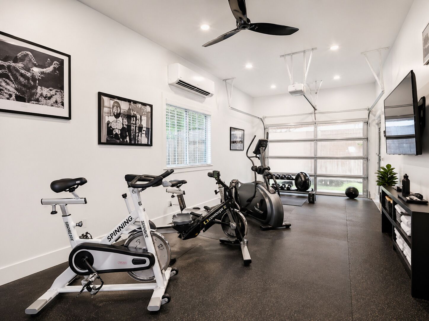 A gym with stationary bikes, a spinning bike, and a ceiling fan.