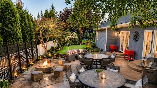 A patio with a fire pit, outdoor furniture, and a grill area.
