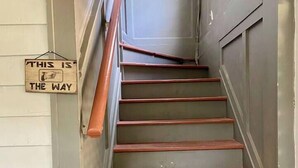 A staircase with wooden steps and a metal handrail. - Light-Filled Loft in 1905 Belhaven Historic Home (Jackson)