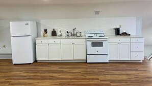 A kitchen with white cabinets, a refrigerator, a stove, and a sink. - Light-Filled Loft in 1905 Belhaven Historic Home (Jackson)