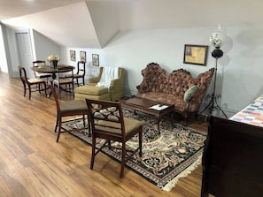 Relax in this stylish living area with a large sofa, round table, and floor lamp.