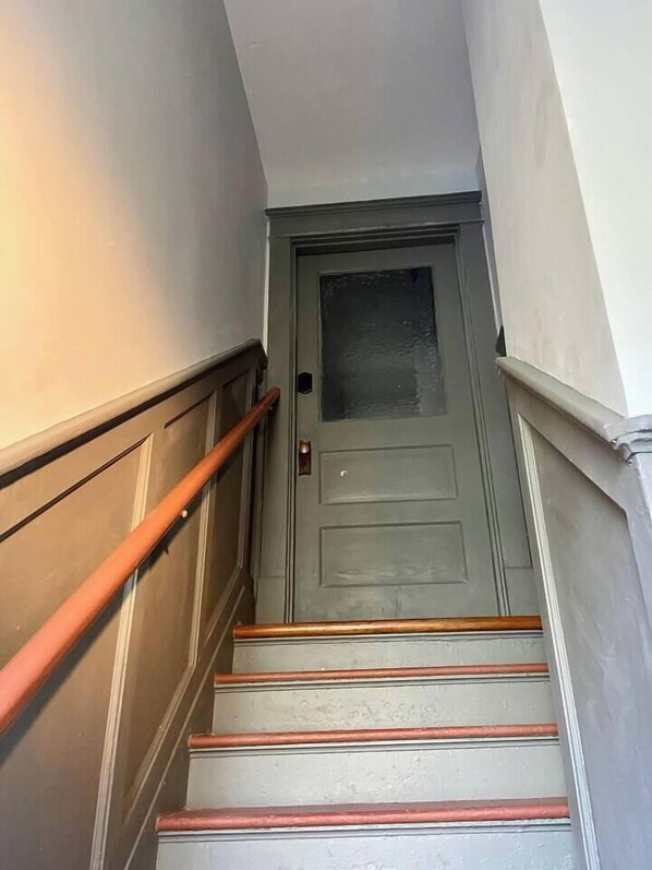 A staircase with wooden handrails and a door at the top.