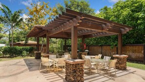An outdoor patio with a pergola, stone pillars, and outdoor furniture. - Tropical Treehouse Near the Beach (Koloa)