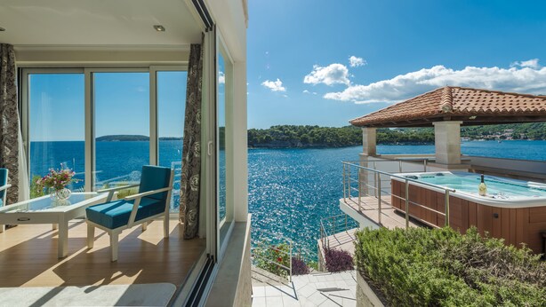A balcony with a view of the sea, a hot tub, and a dining area with a table and chairs. - Spacious 5 bedroom Villa K with sea access  (Zaton)