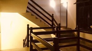 Interior de varios niveles con una escalera y una fuente de luz en el piso superior.