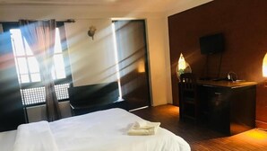 Una habitación de hotel con una cama, un escritorio, una lámpara y un televisor.