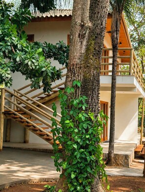 A two-story building with a wooden staircase leading to the upper level. - Pousada Manacá Exclusive Suítes  (Rifaina)