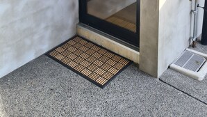 A door labeled G11, a metal doormat, and a concrete wall.