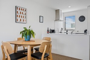 Enjoy a stylish space with a round dining table, potted plant, and modern kitchen area.