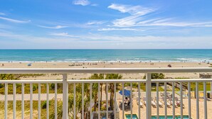 A beach view from a balcony with a pool area and lounge chairs. - Atlantica Resort 2/2 OF Condo with Dishwasher and Washer/Dryer in Myrtle Beach (Myrtle Beach)