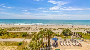 A beach view with a patio area, palm trees, and a pool. - Atlantica Resort 2/2 OF Condo with Dishwasher and Washer/Dryer in Myrtle Beach (Myrtle Beach)