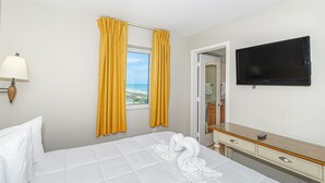 A hotel room with a bed, a TV, a window with curtains, and a view of the beach. - Atlantica Resort 2/2 OF Condo with Dishwasher and Washer/Dryer in Myrtle Beach (Myrtle Beach)