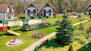 A residential area with two houses, a playground, and a walking path.