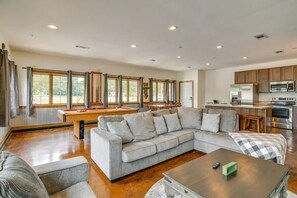 A spacious living room with a grey sectional sofa, a pool table, and a kitchen area with modern appliances. - Boats and Coves Unit 2 / Lots of Boat parking (Diamond City)