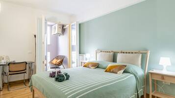 Ein Schlafzimmer mit Bett, Schreibtisch, Stuhl und Lampe.