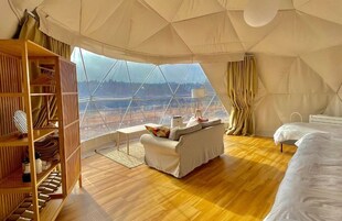 Amplia habitación con toldo, piso de madera, un sofá, una cama y un armario.