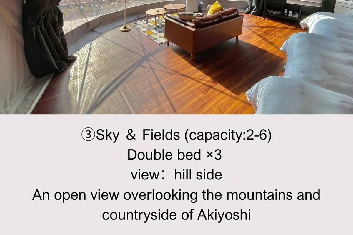 Um quarto amplo com uma cama de casal, um sofá e vista para as montanhas.