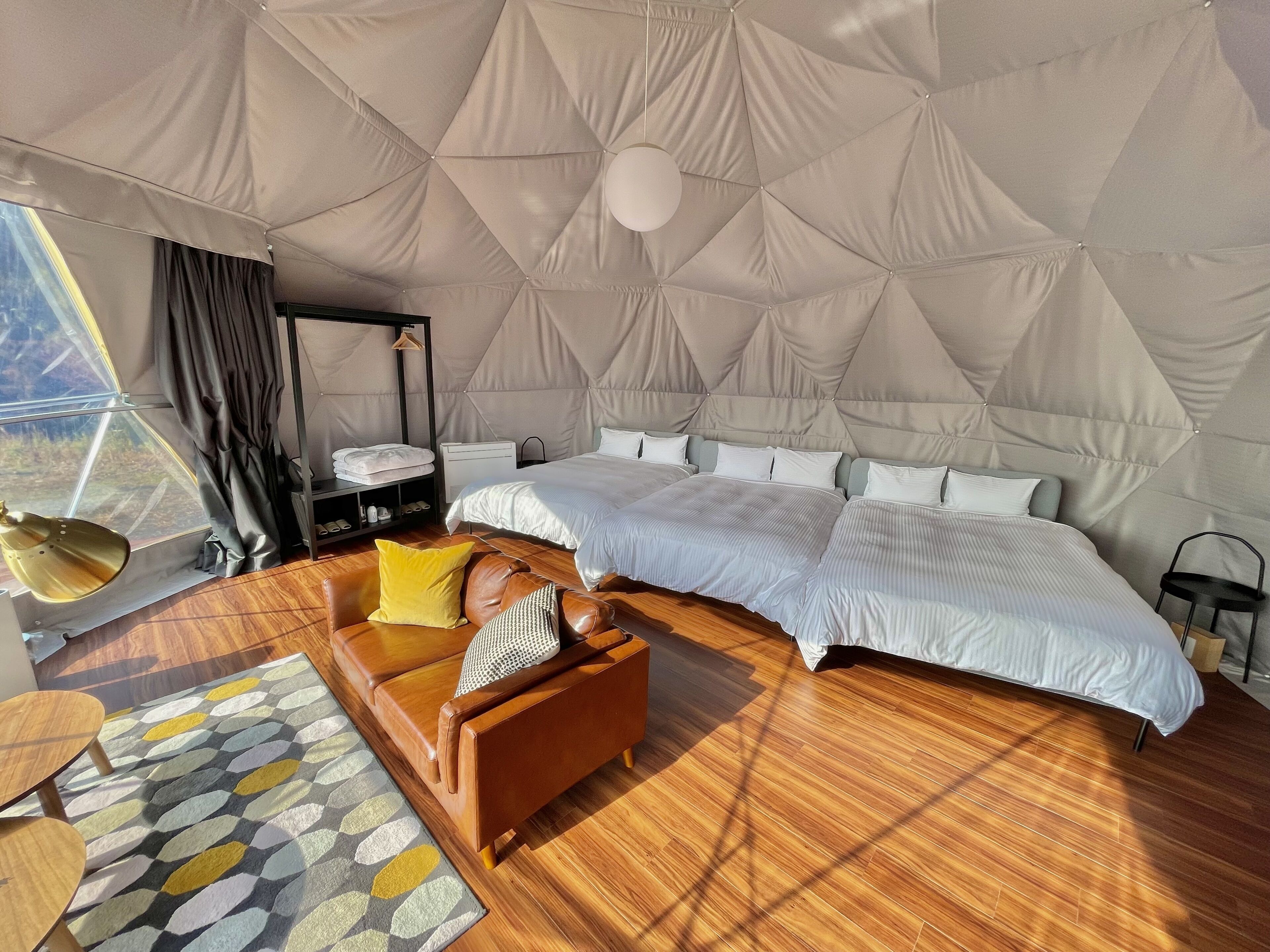 A spacious bedroom with a large bed, a wooden sofa, and a bedside table.