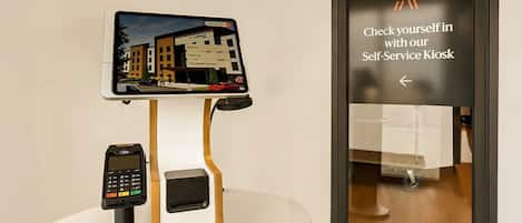 A self-service kiosk with a digital display and a payment terminal.