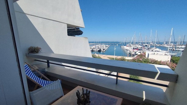En balkon med udsigt over en lysthavn og både.