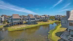 Een woongebied met huizen langs een waterweg, met moderne architectuur en buitenruimtes.