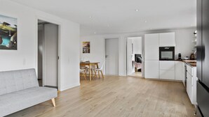 A modern kitchen with white cabinets, a built-in oven, and a stainless steel refrigerator. - Gorgeous home in Melby with WiFi (Melby)