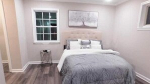 Ein Schlafzimmer mit einem Bett, einem Fenster und einem Wandbild.