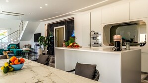 A modern kitchen with a marble countertop, a coffee machine, and a fruit bowl. - Elegant villa with pool in Mascali (Mascali)
