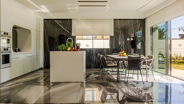 A modern kitchen with a central island, a dining area with chairs, and a large window. - Elegant villa with pool in Mascali (Mascali)