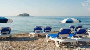 A beach with rows of blue and white lounge chairs and umbrellas. - Altea Suite Vault by Vero (Altea)