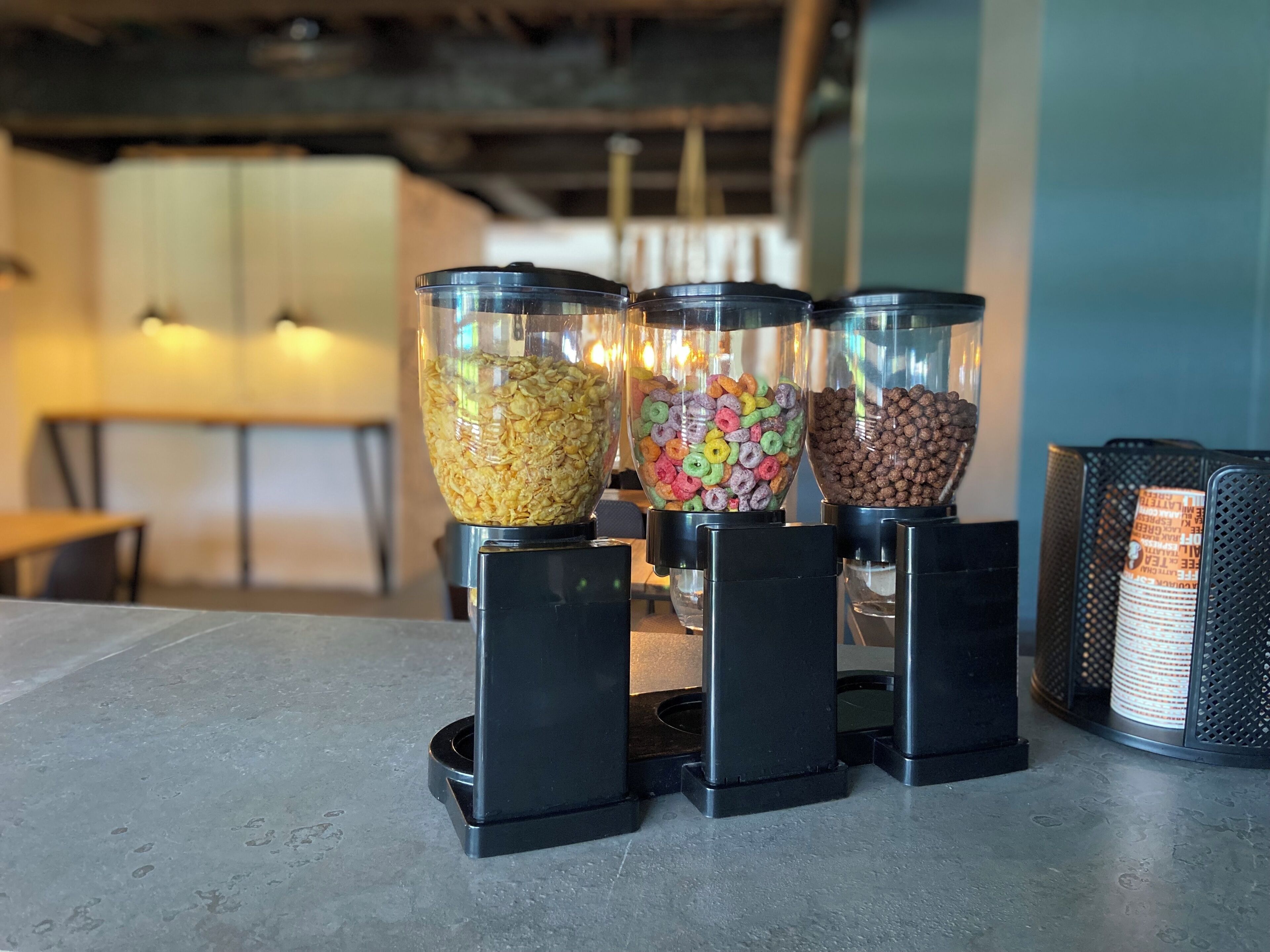 Three glass dispensers on a counter with different contents.