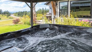 Boblebad med udsigt til et hus og grønne omgivelser.