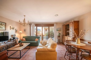 Relax in this stylish living room with a sofa, coffee table, and TV. Enjoy meals at the dining table and take in the view from the large window.