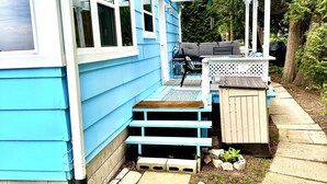A blue house with a porch, a small garden, and a stone pathway. - "The Lake House" With Spectacular Views!!! Steps to Beach!! (Port Elgin)