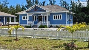 A two-story house with a blue exterior, white trim, and a front porch.