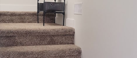 Una escalera alfombrada con una pequeña mesa en la parte superior.