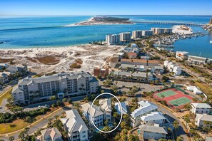 An aerial view of a coastal resort area with beachfront properties, a marina, and a pier extending into the water. - The Hummingbird - Lakefront Vacation Home with Private Pool & Water Views (Destin)