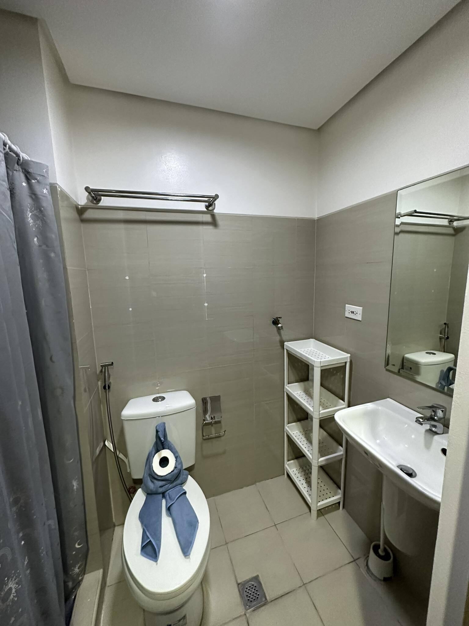 A bathroom with a toilet, sink, and shower.